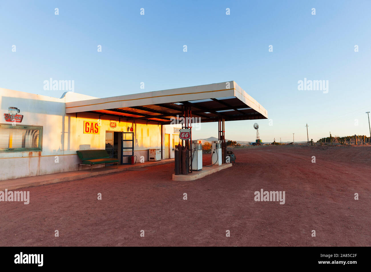 Abbandonata la stazione di gas e garage al tramonto Foto Stock