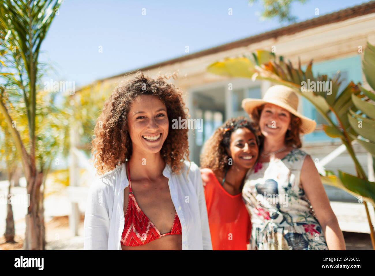 Ritratto felice madre e due figlie al di fuori di sunny beach hut Foto Stock