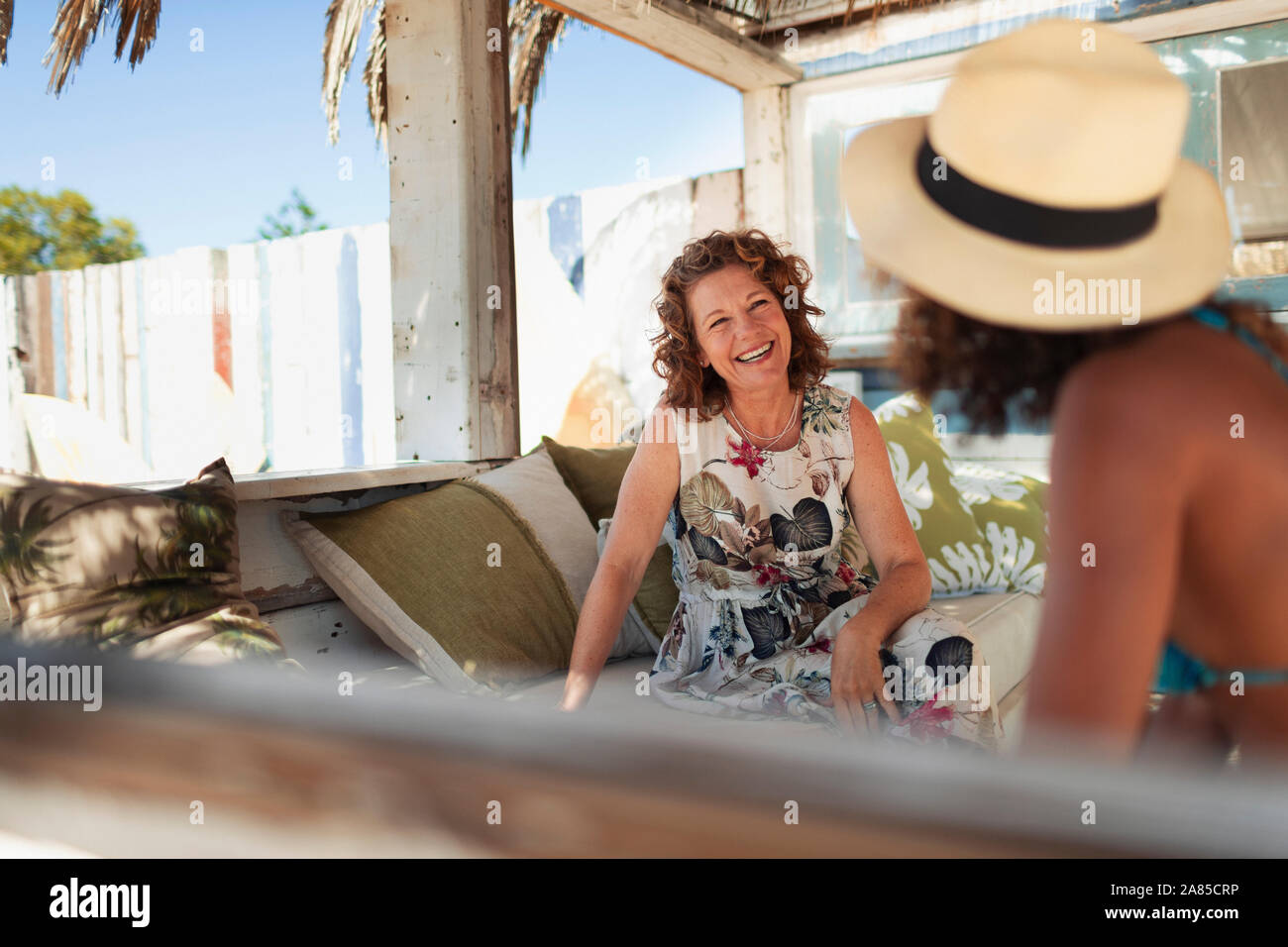 Felice madre e figlia adulta parlando sulla spiaggia patio Foto Stock