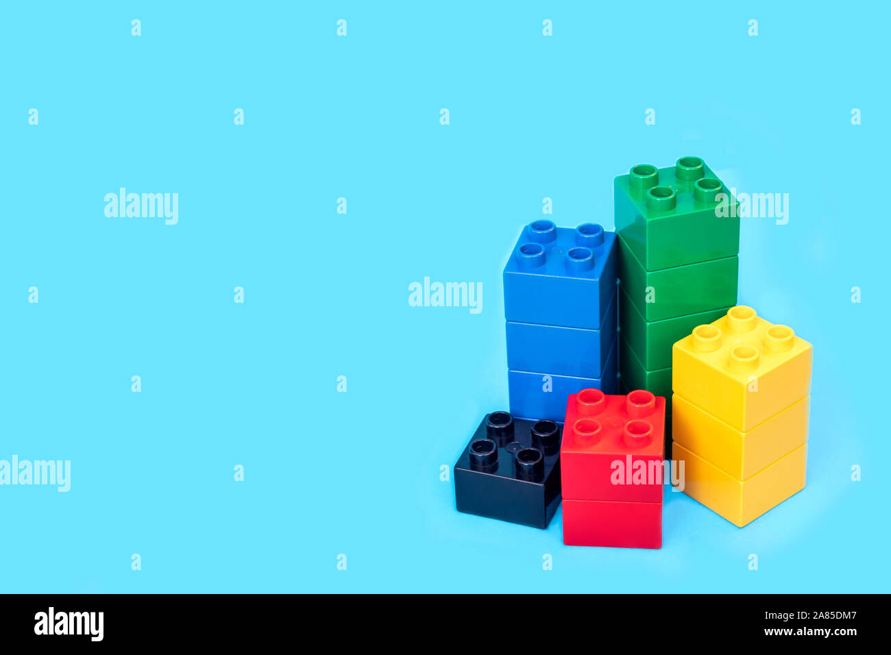 I grafici a barre in plastica blocchi di costruzione di mattoni giocattolo su sfondo blu. Foto Stock