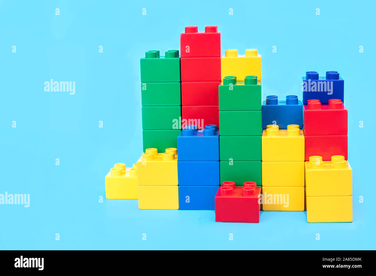 I grafici a barre in plastica blocchi di costruzione di mattoni giocattolo su sfondo blu. Foto Stock