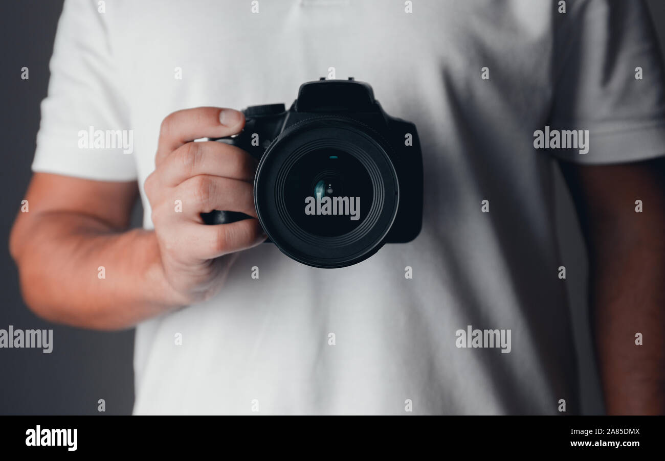 Fotografo in possesso di una fotocamera digitale Foto Stock