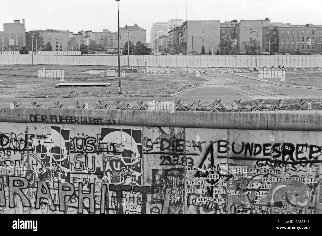 Graffiti an der Berliner Mauer mit Blick in den Ostteil der Stadt, Deutschland 1984. Il muro di Berlino decorato con graffiti e una vista della parte orientale della città, Germania 1984. Foto Stock