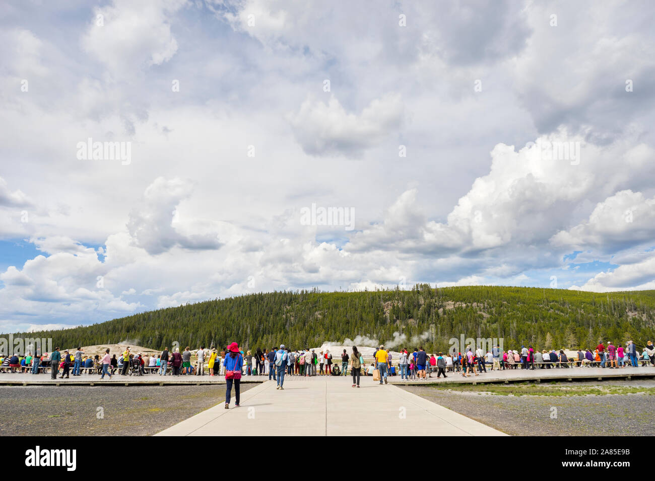 I turisti attendere e guardare per il geyser Old Faithful a scatenarsi Foto Stock