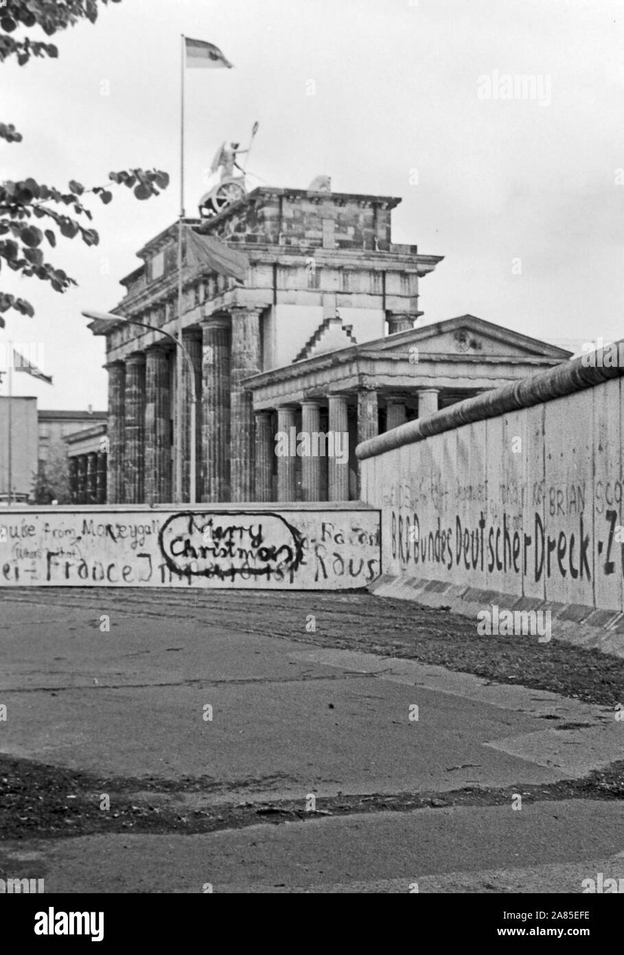 Weihnachtswünsche aufgesprüht auf die Mauer in Berlin am Brandenburger Tor, Deutschland 1984. Fuone Feste spruzzato sul muro di Berlino vicino alla Porta di Brandeburgo, Germania 1984. Foto Stock