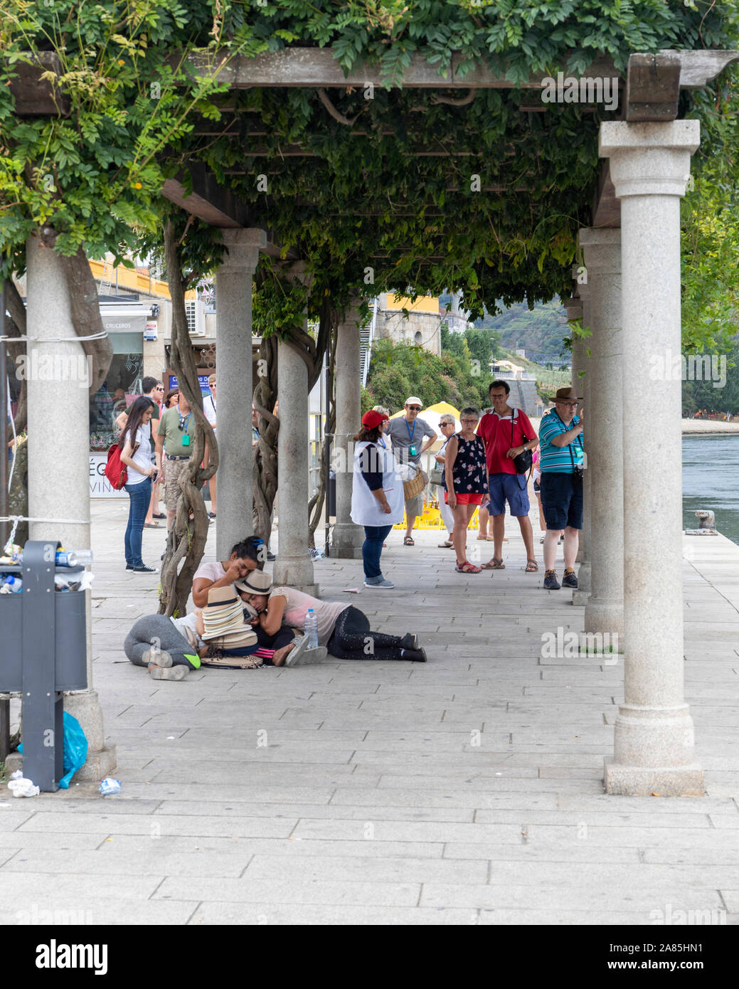 Tre esaurito femmina fornitori hat addormentarsi sul marciapiede di attesa per la prossima partita di turisti di sbarcare dalla loro nave da crociera Foto Stock