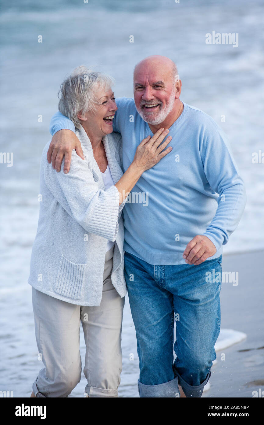 Coppia senior camminando lungo la riva Foto Stock