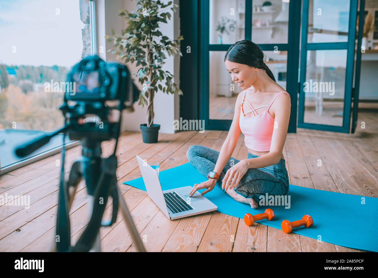 Blogger Fitness utilizzando il proprio portatile mentre si lavora sul nuovo video Foto Stock