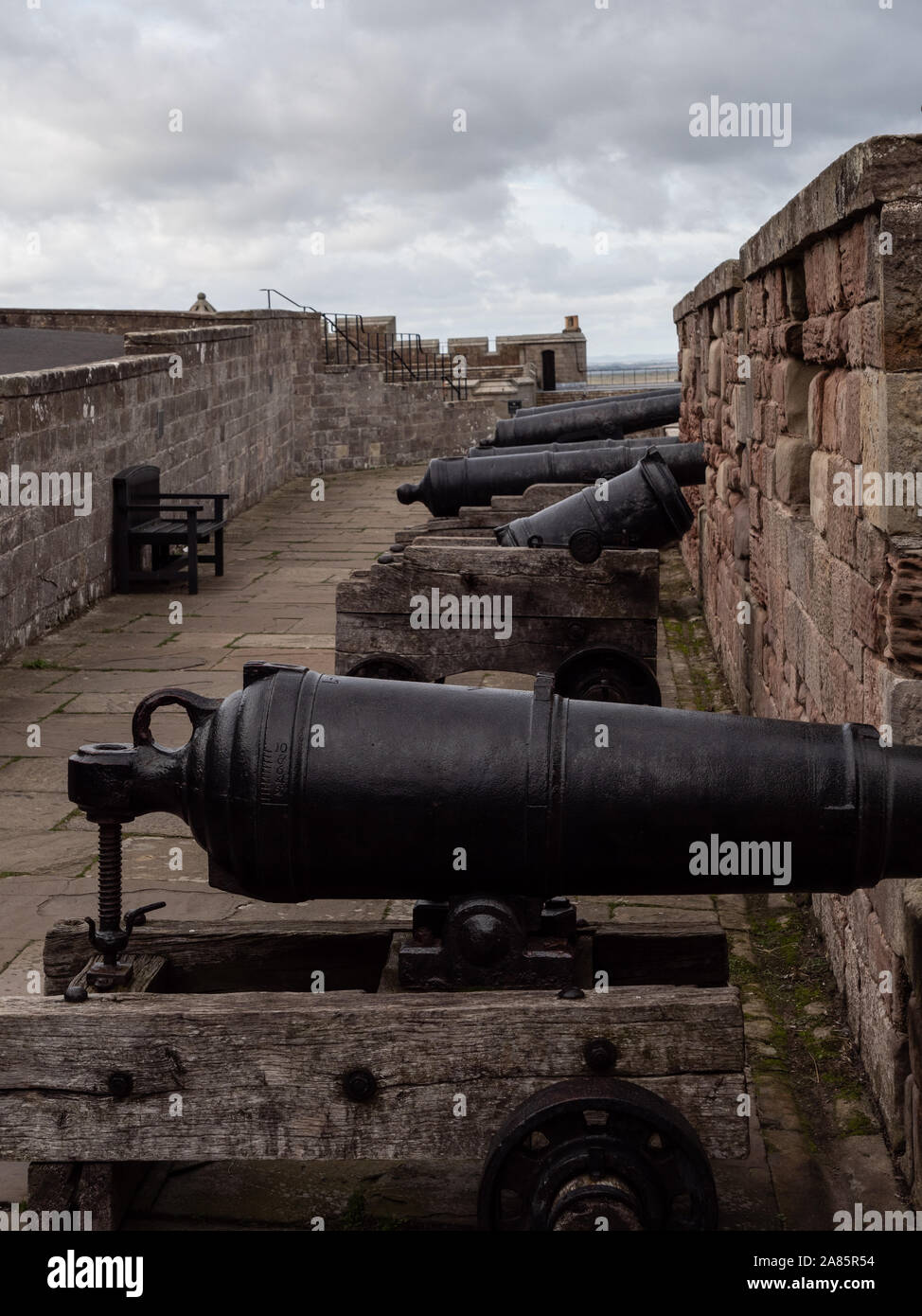 Il Cannone e mortaio sui bastioni presso il castello di Bamburgh, Northumberland, Regno Unito. Foto Stock