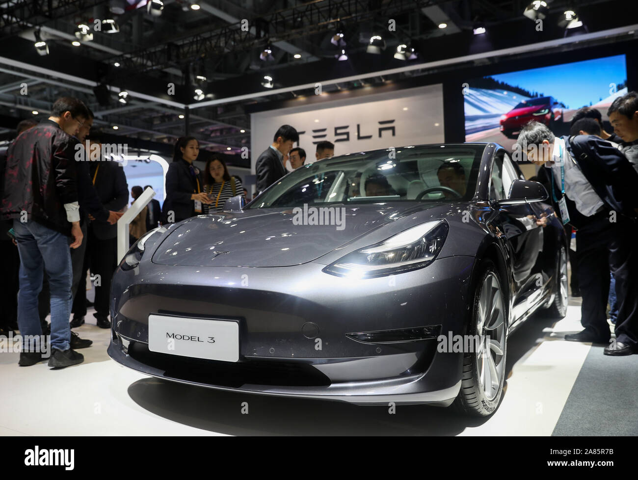 (191106) -- Shanghai, nov. 6, 2019 (Xinhua) -- persone di visualizzare un modello di Tesla 3 presso l'Automobile area espositiva durante la seconda China International Import Expo (CIIE) a Shanghai in Cina orientale, nov. 6, 2019. Il National Exhibition and Convention Centre di Shanghai ha salutato un gran numero di visitatori durante la seconda giornata del CIIE. (Xinhua/Ding Ting) Foto Stock