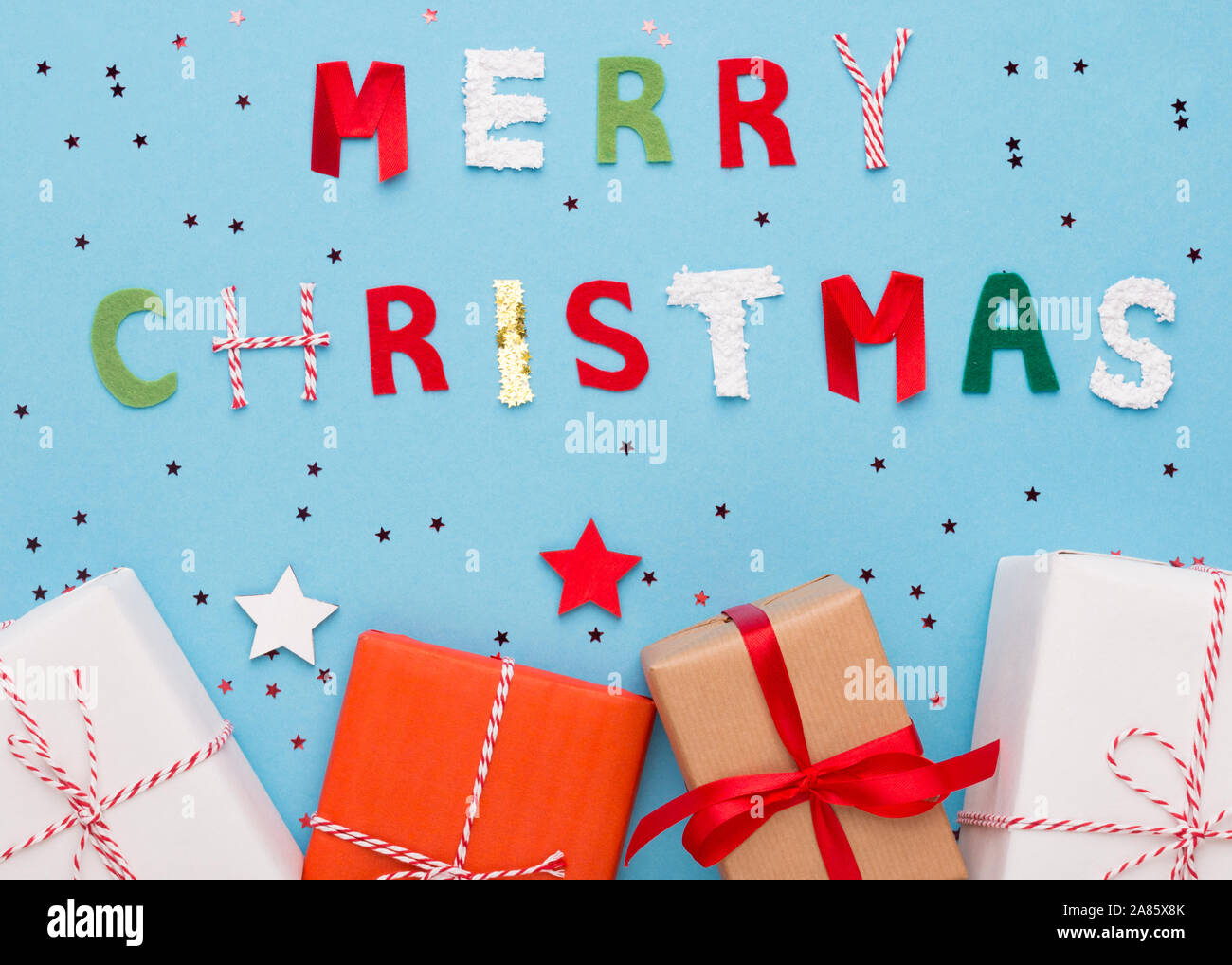 Buon Natale auguri e doni in scatole su sfondo blu Foto Stock