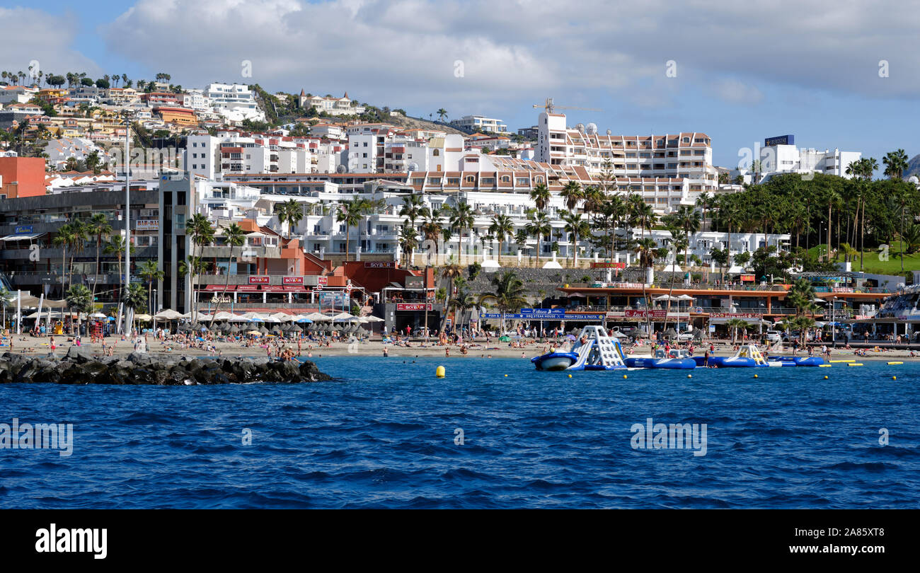 Tenerife, Spagna - 15 ottobre 2019: Vista sul mare della costa di Los Cristianos, la gente gode della bella spiaggia dell'Oceano Atlantico, città turistica, Sp Foto Stock