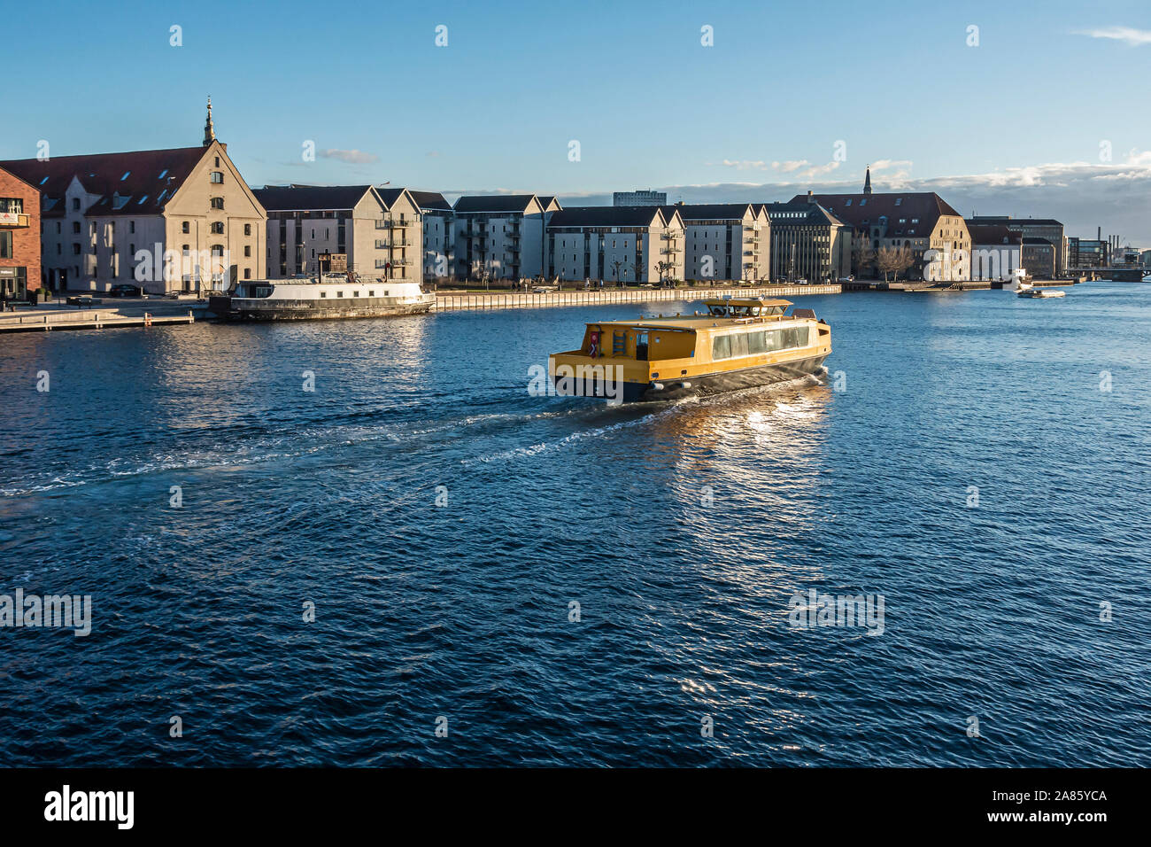 Porto danese Nordhavn bus passa attraverso il lato del porto di Christianshavn nel porto di Copenhagen DANIMARCA avendo appena passato sotto Inderhavnsbroen Foto Stock