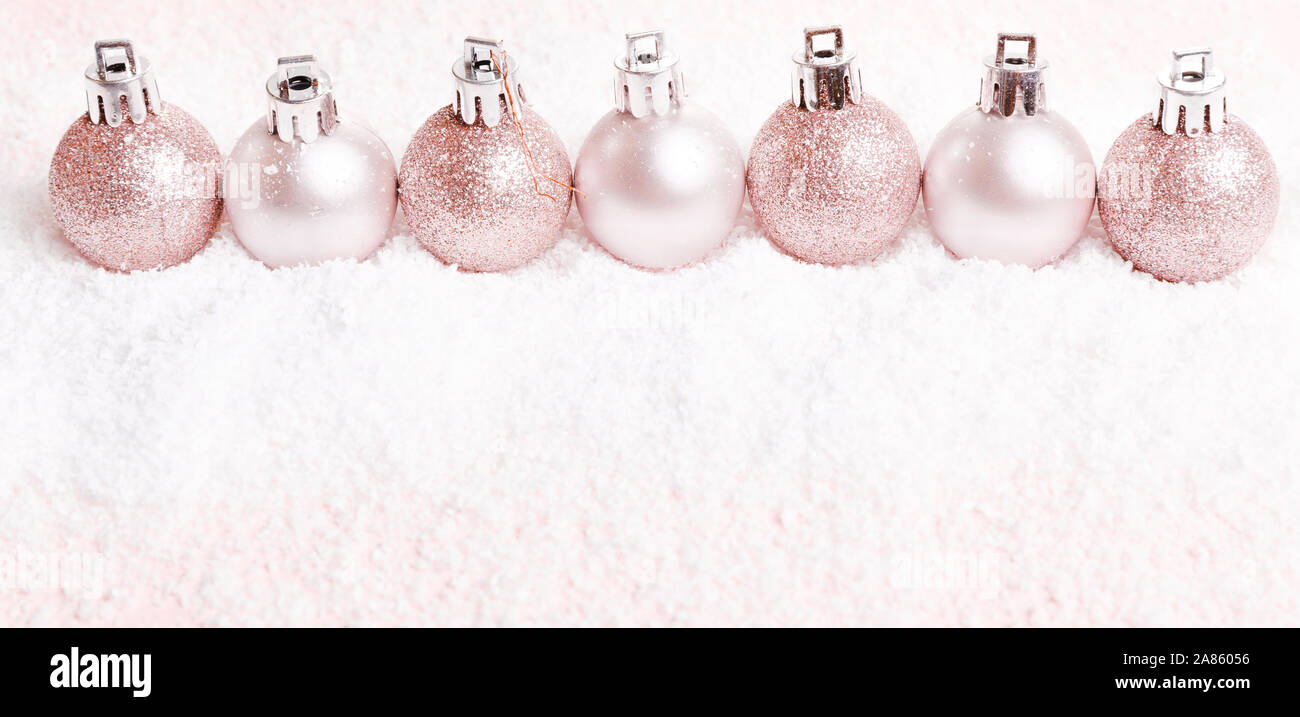 Composizione di natale. rosa e argento palle di Natale sulla neve sullo sfondo bianco. Foto Stock