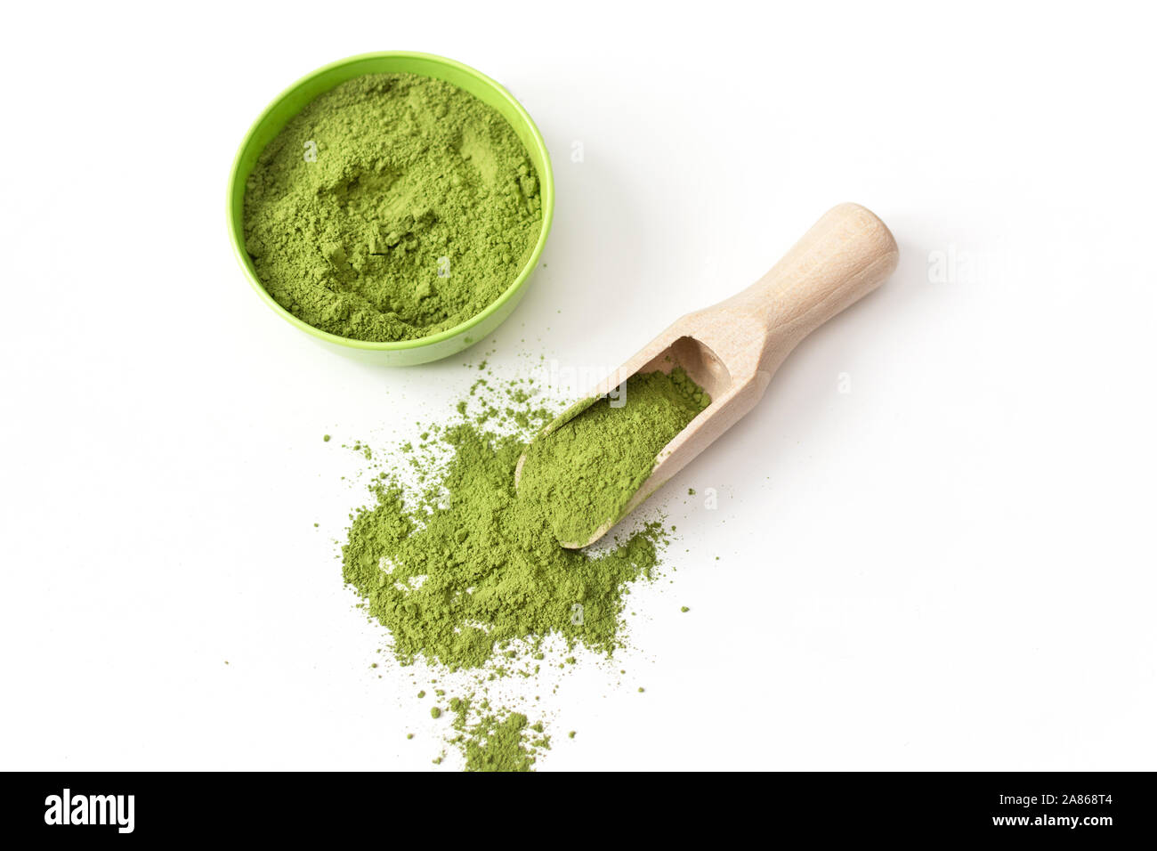 Il cucchiaio di legno con polvere di tè verde Matcha nella tazza, isolati su sfondo bianco. Foto Stock