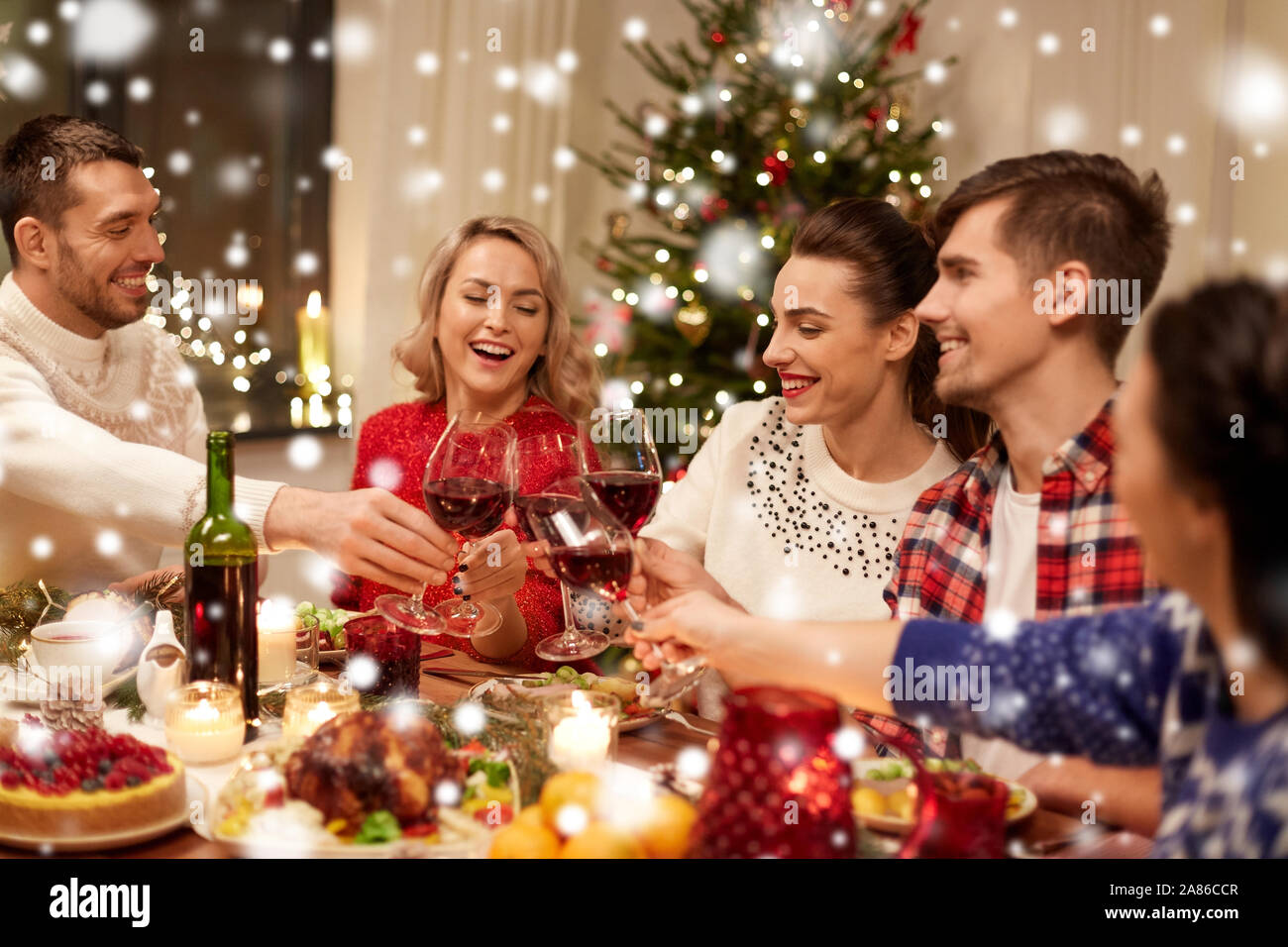 Amici festeggiano il Natale e bere il vino Foto Stock