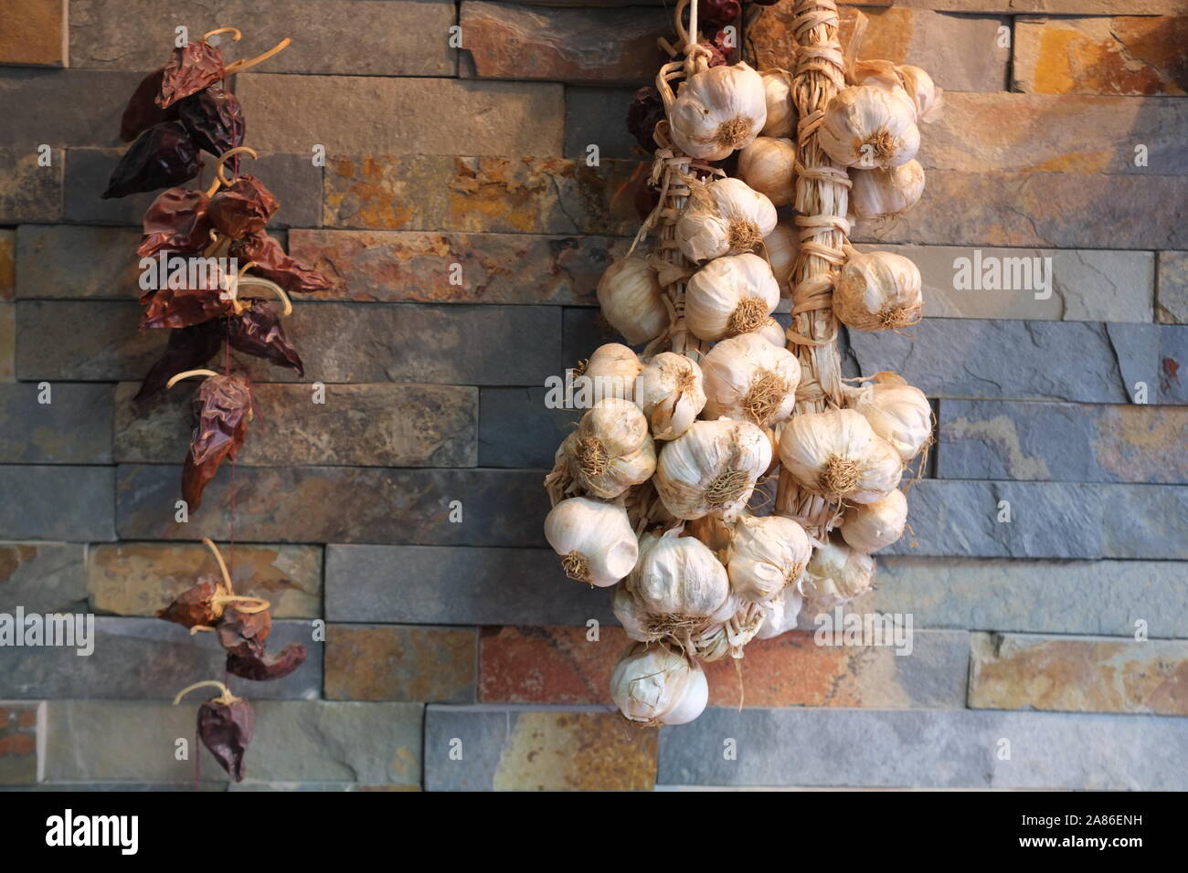 Asciugare le cipolle e i peperoni sulla parete, cool idea, grande decorazione Foto Stock