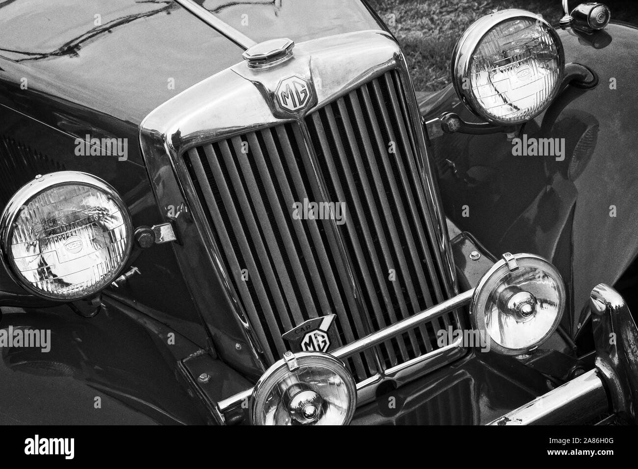 Ad angolo vista anteriore di una classic vintage tipo MG T auto sportiva che mostra i proiettori e le luci di guida, griglia del radiatore e chromework. Foto Stock