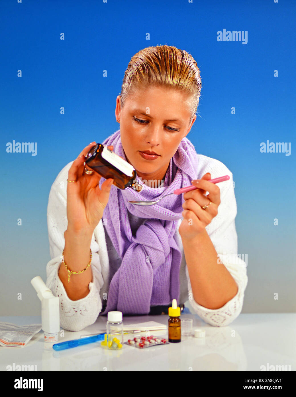 Blonde Frau nimmt Medizin gegen eine Erkaeltung, Foto Stock