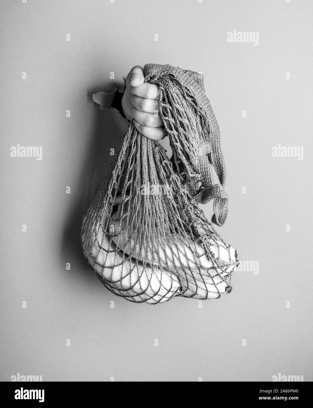 Una donna può contenere riutilizzabile stringa di cotone Portable Shopping borsetta. Foto in bianco e nero Foto Stock