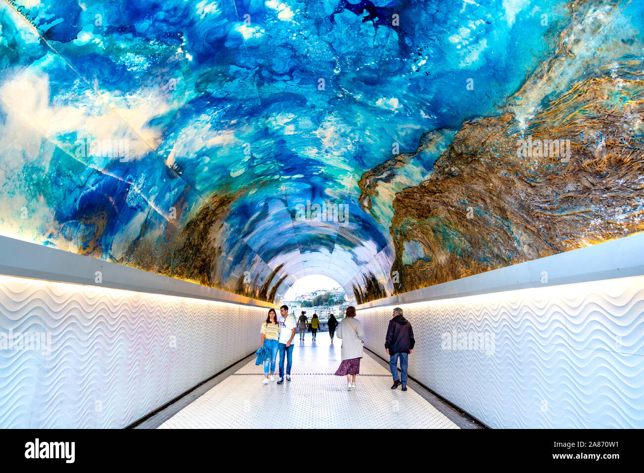 La gente a piedi attraverso il tunnel di Miramar decorate con opere d'arte dell'artista Victor Goikoetxea, San Sebastian, Spagna Foto Stock