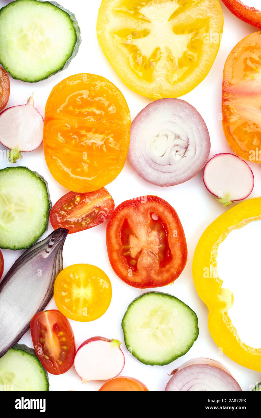 Luminose colorate sullo sfondo di verdure. Ingredienti per insalata e pomodori peperoni cetriolo cipolla tagliata su bianco, vista dall'alto, il fuoco selettivo Foto Stock