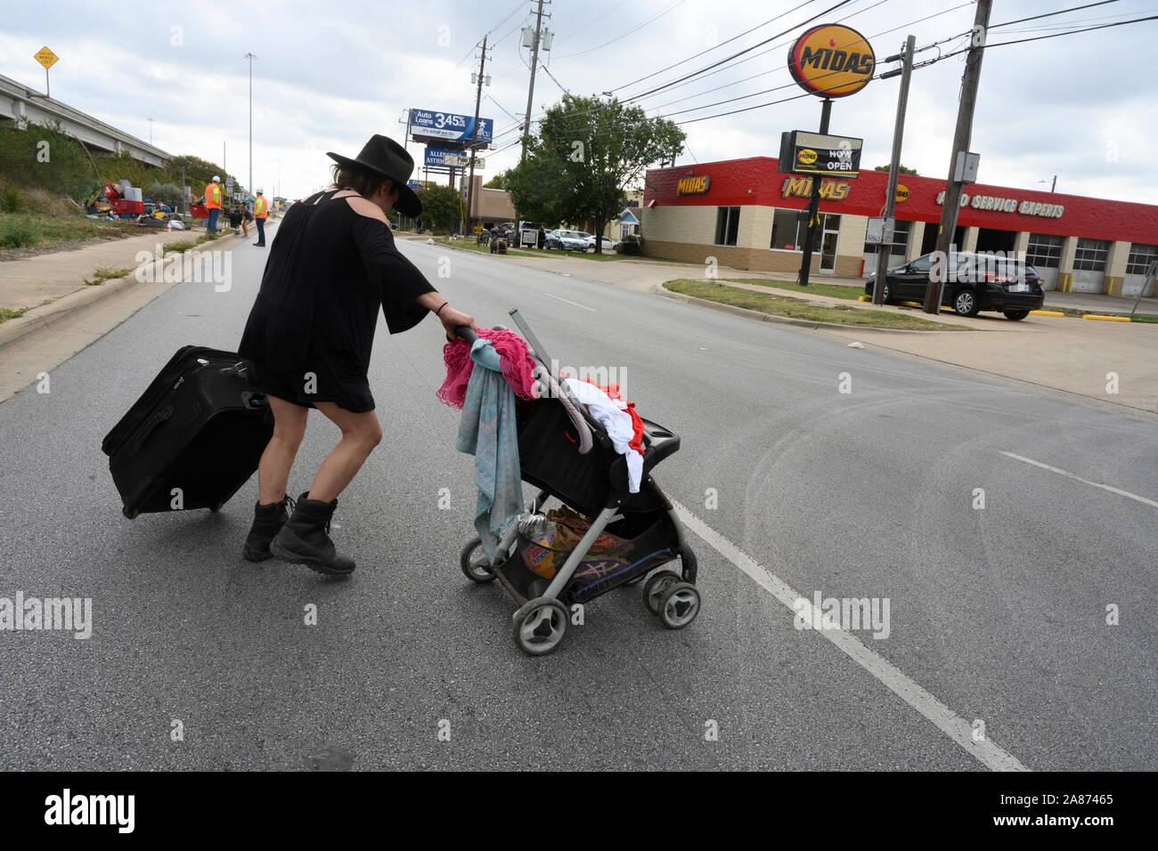 Austin, Texas USA nov. 6, 2019: Jay attraversa la strada con i suoi averi dopo essere stato buttato fuori del diritto dello Stato di modo durante il terzo giorno di uno Stato-sancita senzatetto camping La repressione in Texas' città capitale. Per gli ordini dal Texas Gov. Greg Abbott, autostrada equipaggi sono cancellazione 17 identificate nei campi sfollati su autostrade principali. Foto Stock