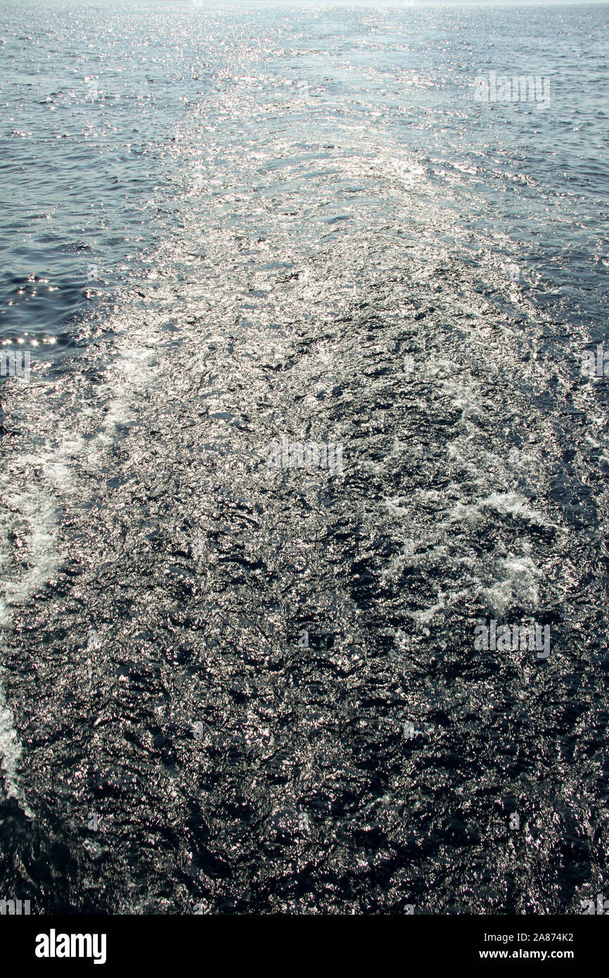 Sentiero dell'acqua sul mare blu dopo la grande nave con due motori Foto Stock