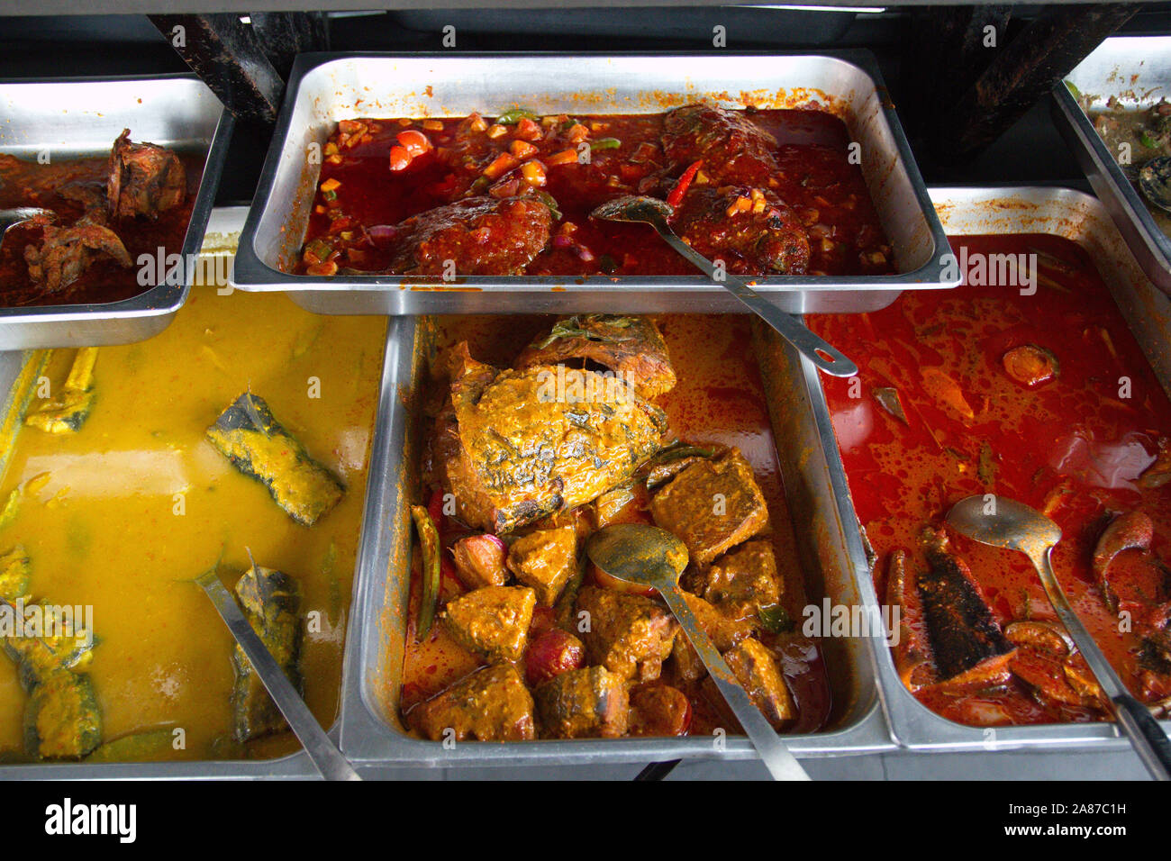Gli alimenti precotti in vassoi di acciaio a Haji Yahya ristorante malese in Ipoh, Perak, Malaysia Foto Stock