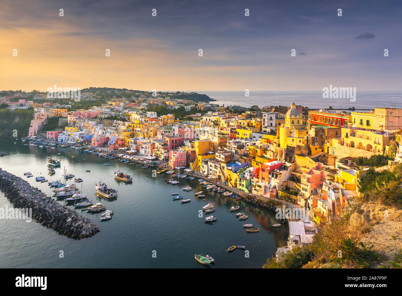 Isola di Procida e villaggio con case colorate al tramonto. Destinazione di viaggio vicino a Napoli in Campania, Italia. L'Europa. Foto Stock