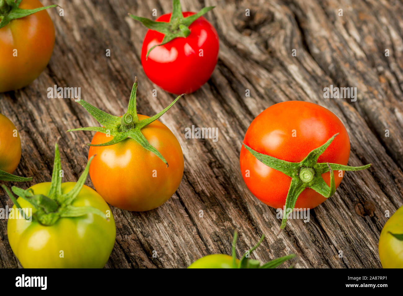 Pomodori colorati su una superficie in legno vicino. Un sano cibo biologico. Foto Stock