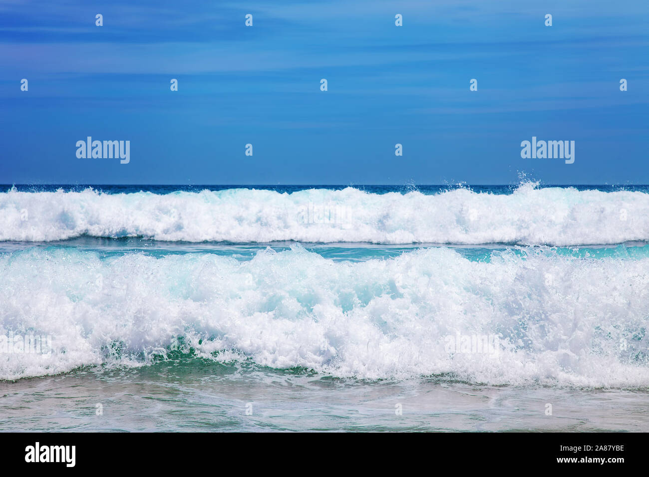 Blue Sea Wave con schiuma bianca e cielo Foto Stock