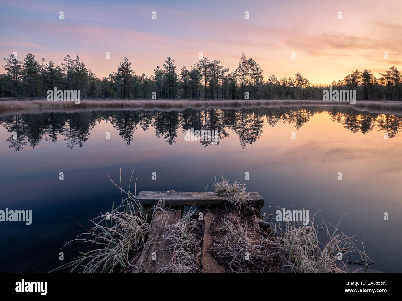 Calma e fredda mattina autunnale paesaggio con sunrise, frosty pier e tranquillo lago in Finlandia Foto Stock