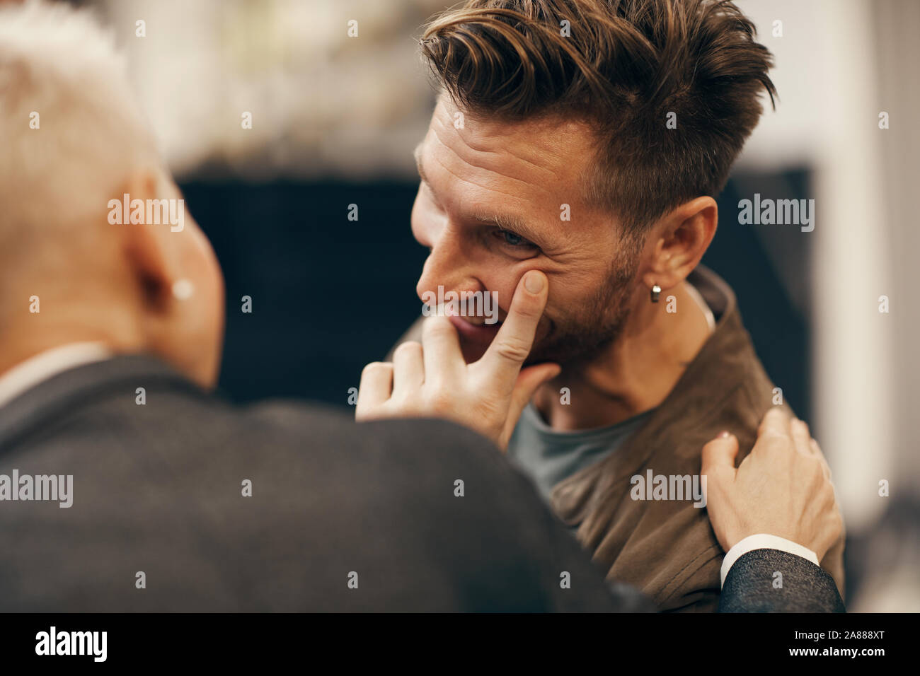 Felice giovane uomo che parla di donna matura e sorridente durante il loro incontro Foto Stock