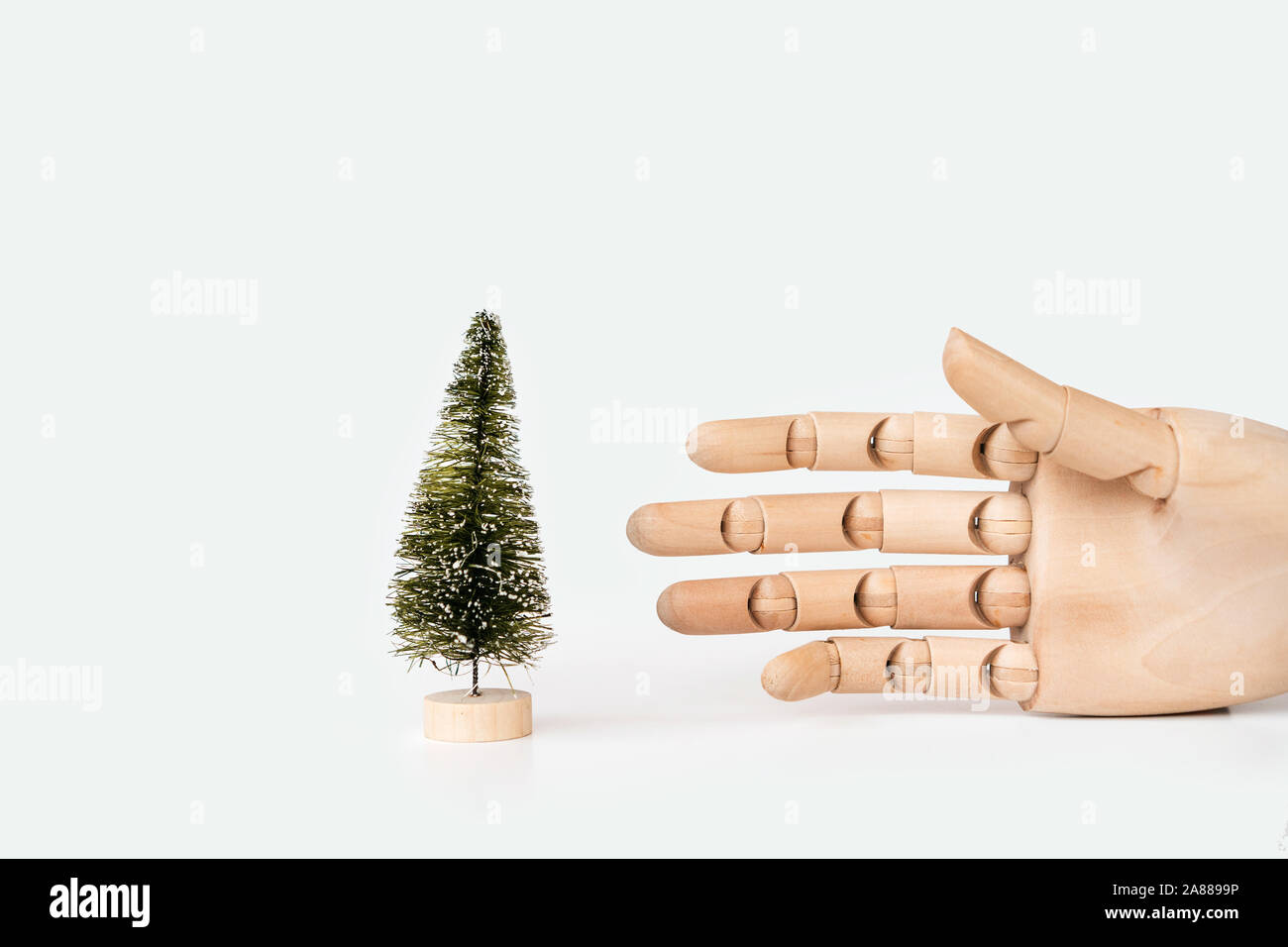 Natale albero artificiale su un supporto di legno e un mock up di una mano Foto Stock