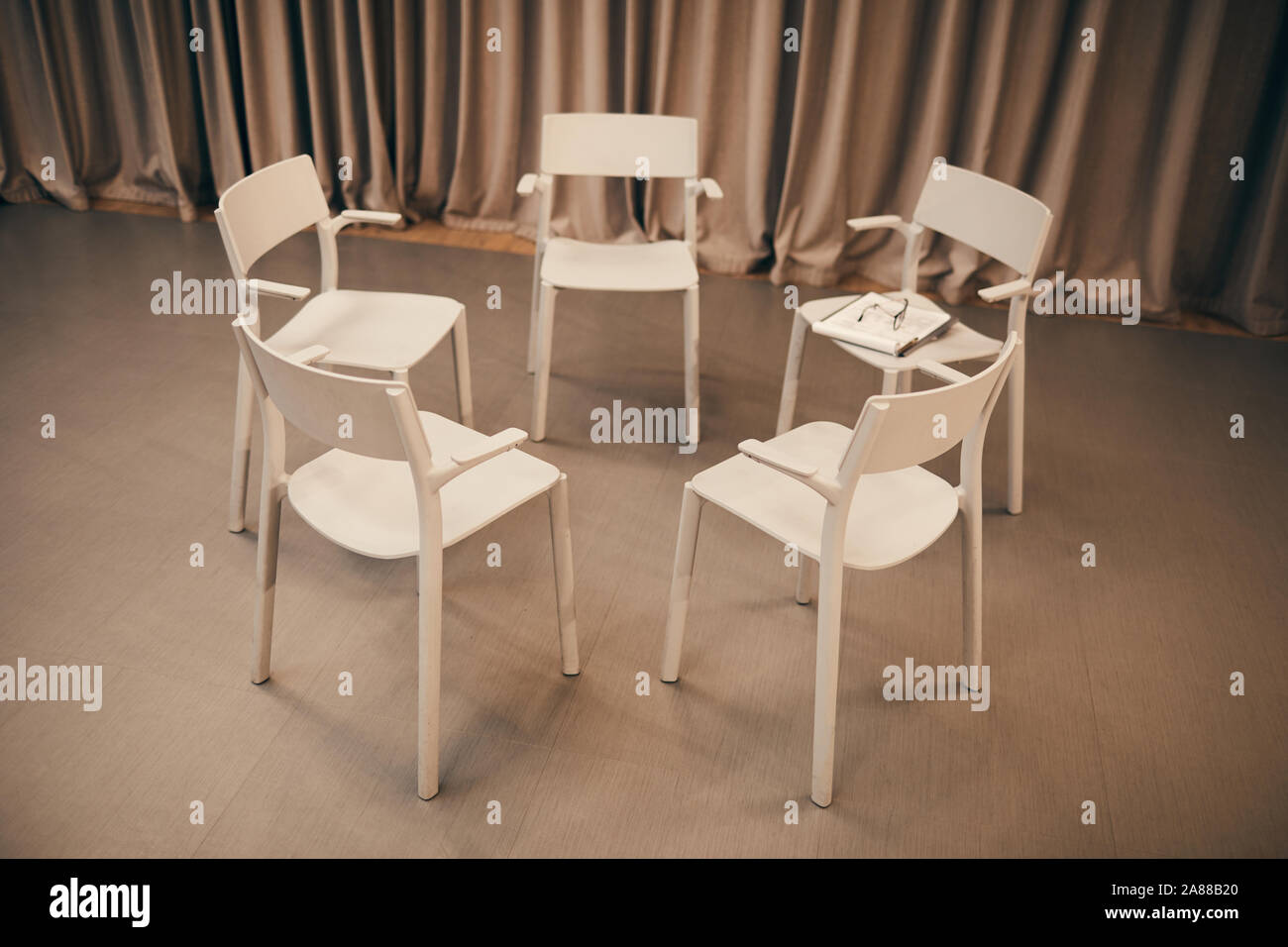 Immagine di sedie bianche in piedi in cerchio in camera hanno preparato per la riunione Foto Stock