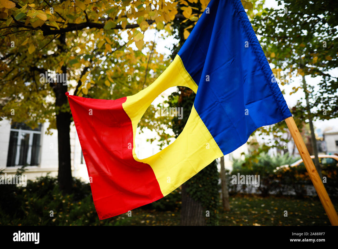 Dettagli con la bandiera rumena con un foro, il simbolo della rivoluzione romena da dicembre 1989 quando l'emblema comunista è stato tagliato fuori dal fl Foto Stock