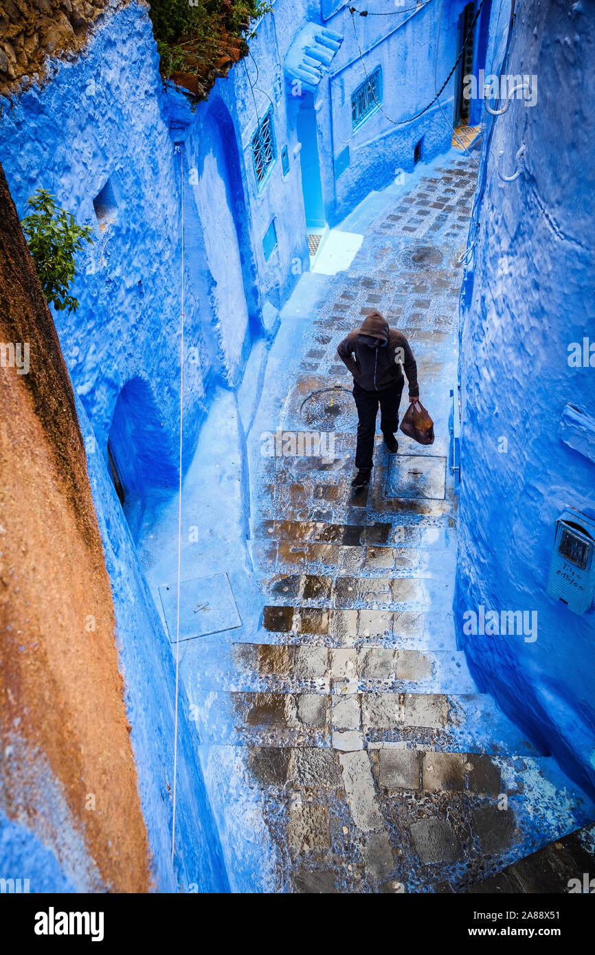 Marocco: Chefchaouen, la città blu. Uomo in un vicolo della medina Foto Stock