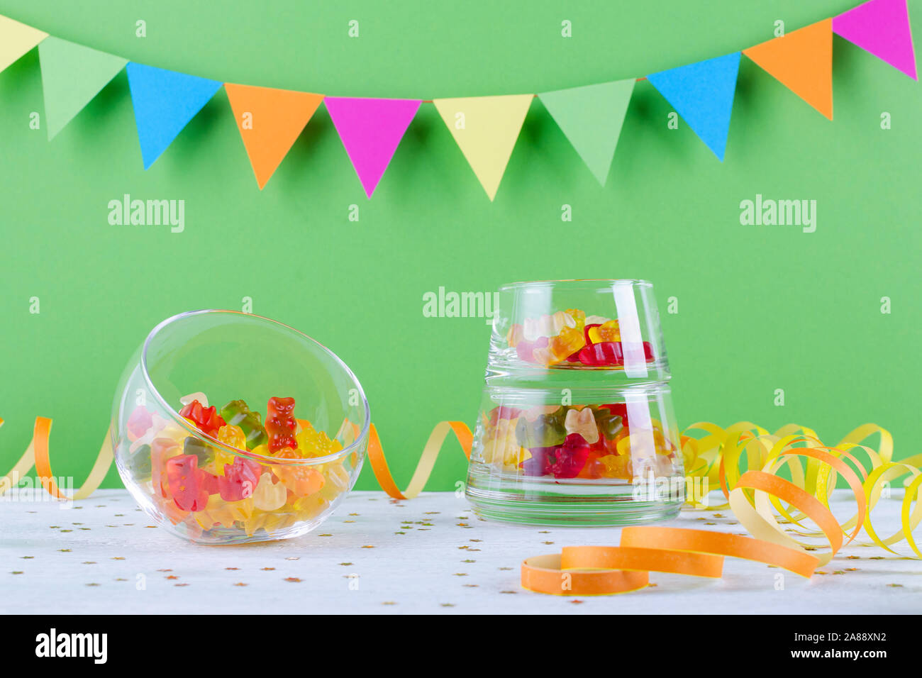 Jelly candy in recipiente di vetro sulla parte verde sullo sfondo Foto Stock