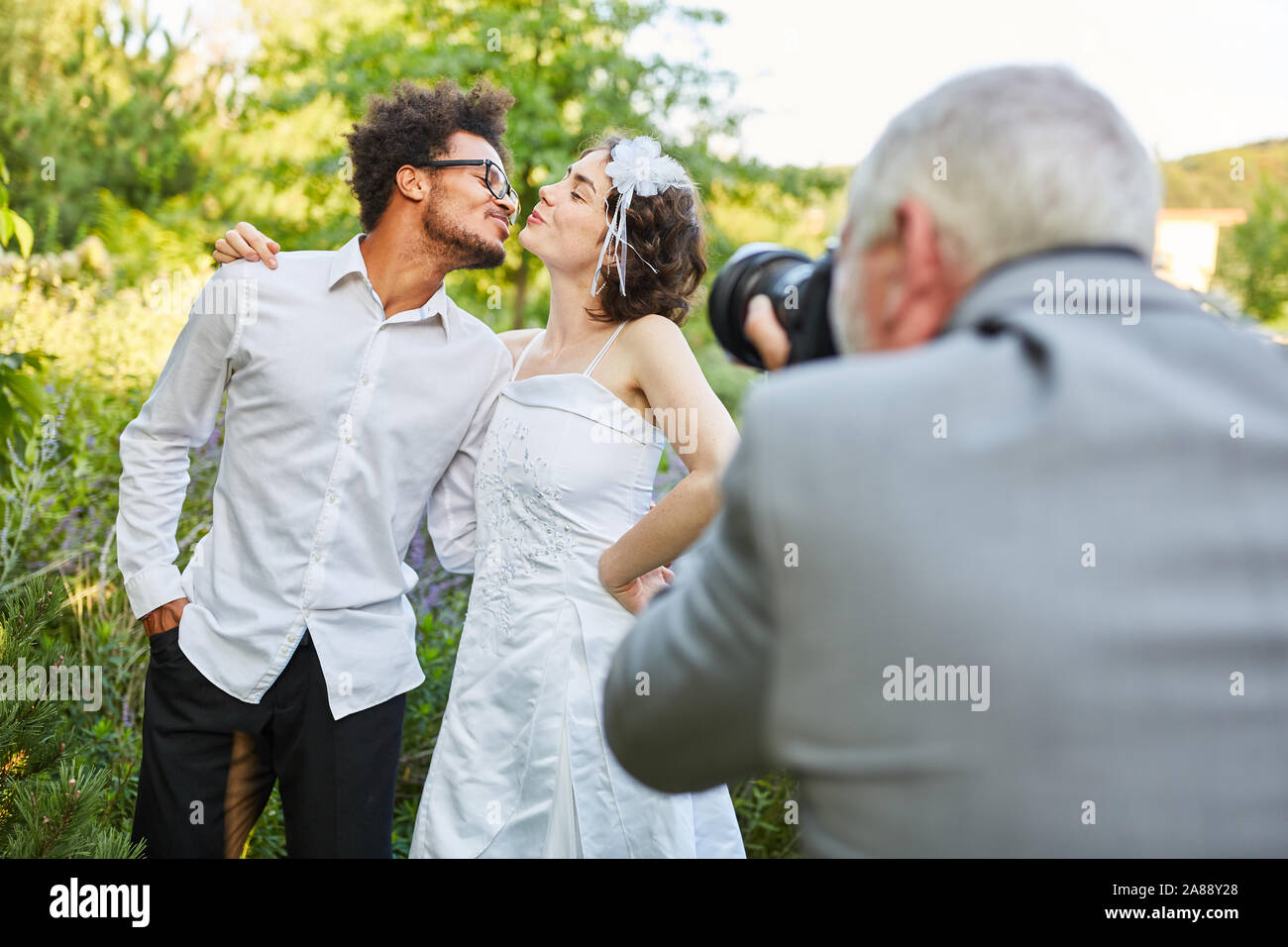 Fotografo matrimonio foto sposi novelli kissing che il giorno del matrimonio Foto Stock