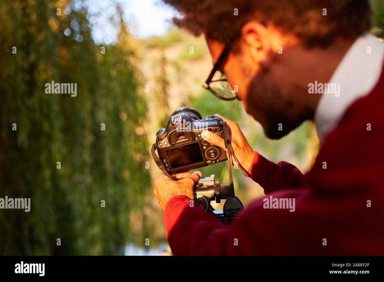 Il fotografo come un fotografo di natura o Wildlife Photographer fermi la fotocamera sul cavalletto Foto Stock