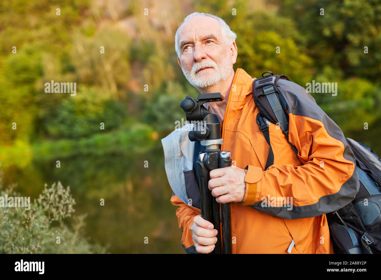 Fotografo naturalista con esperienza in natura sulla strada con il cavalletto e zaino Foto Stock