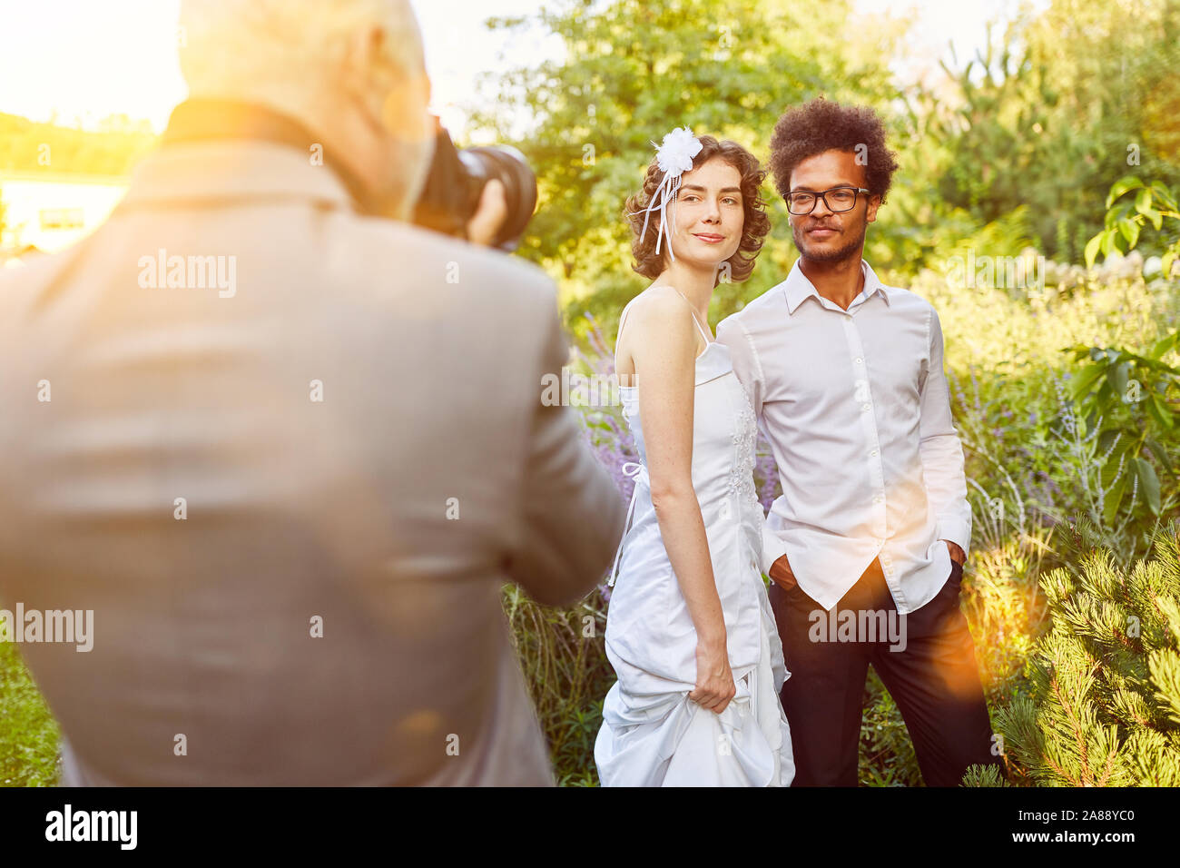 Fotografo per matrimoni a scattare foto di sposi novelli a un matrimonio in natura Foto Stock