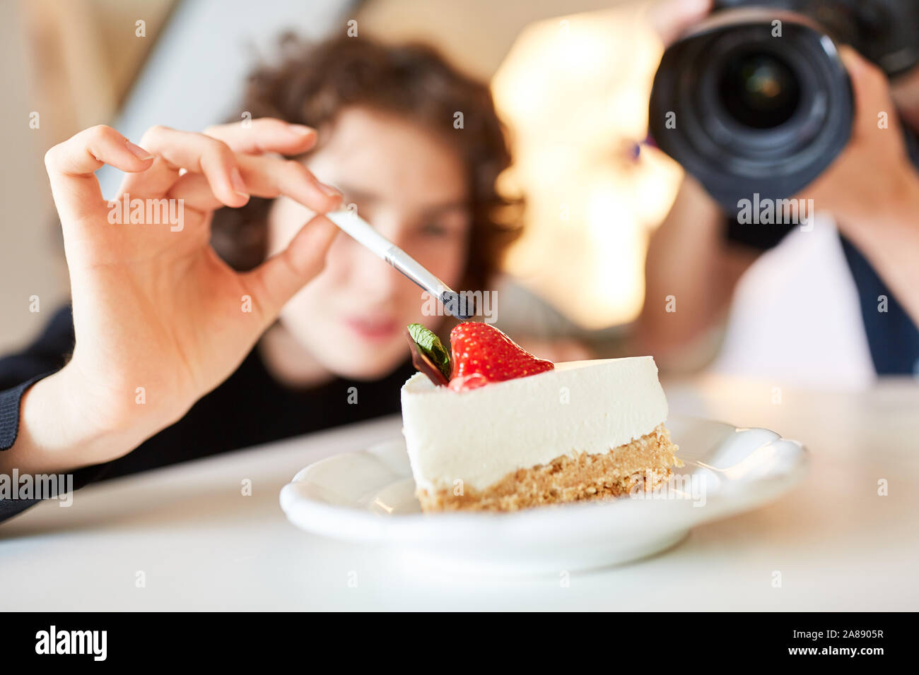 Stylist con spazzola e torta cibo durante lo styling per scattare una foto Foto Stock