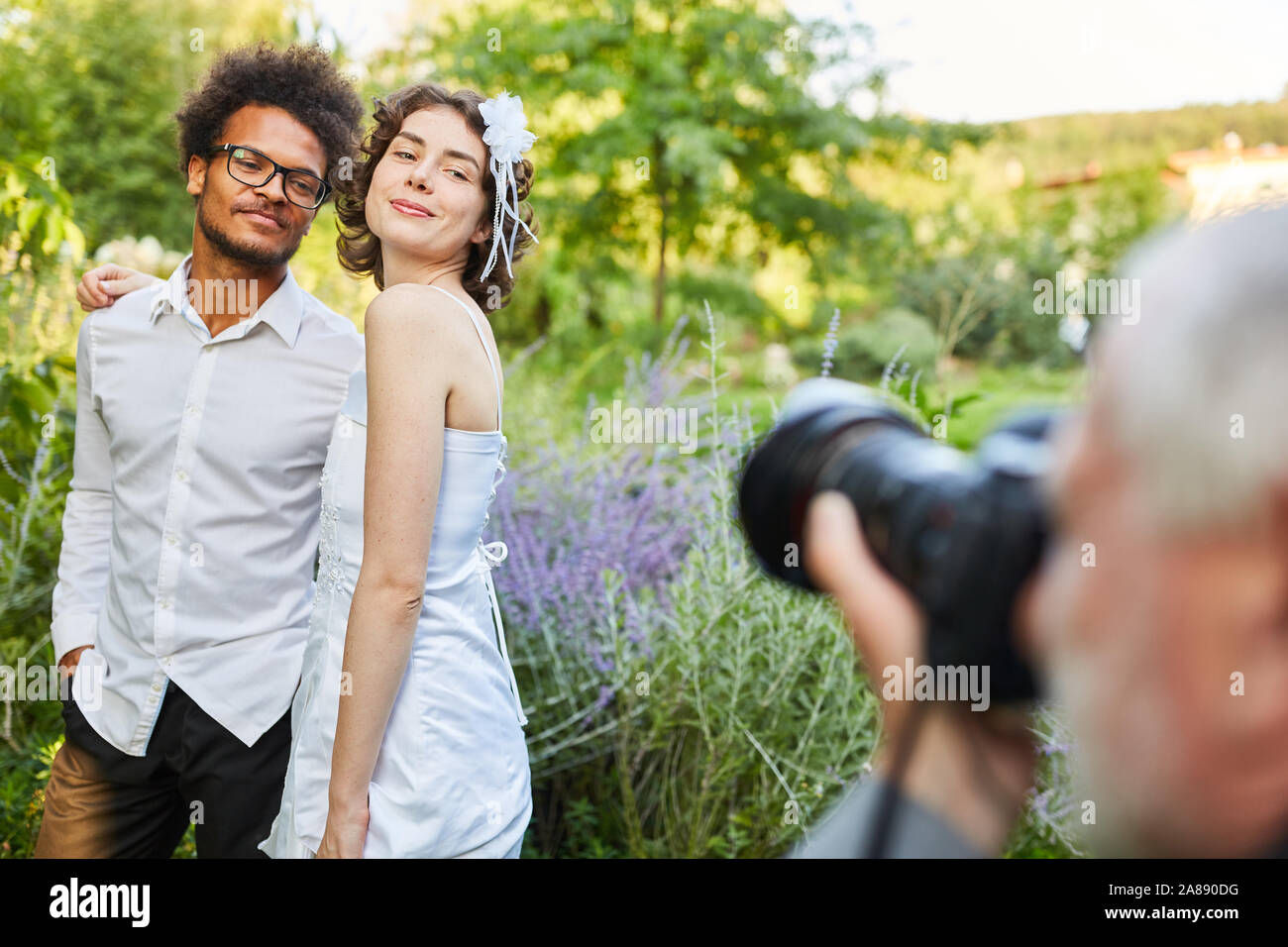 Fotografo prende le immagini di felice sposi il giorno del matrimonio nella natura Foto Stock