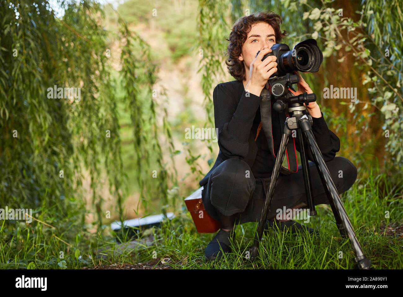 Fotografo di natura con videocamera e treppiede nel paesaggio la fotografia come un hobby Foto Stock