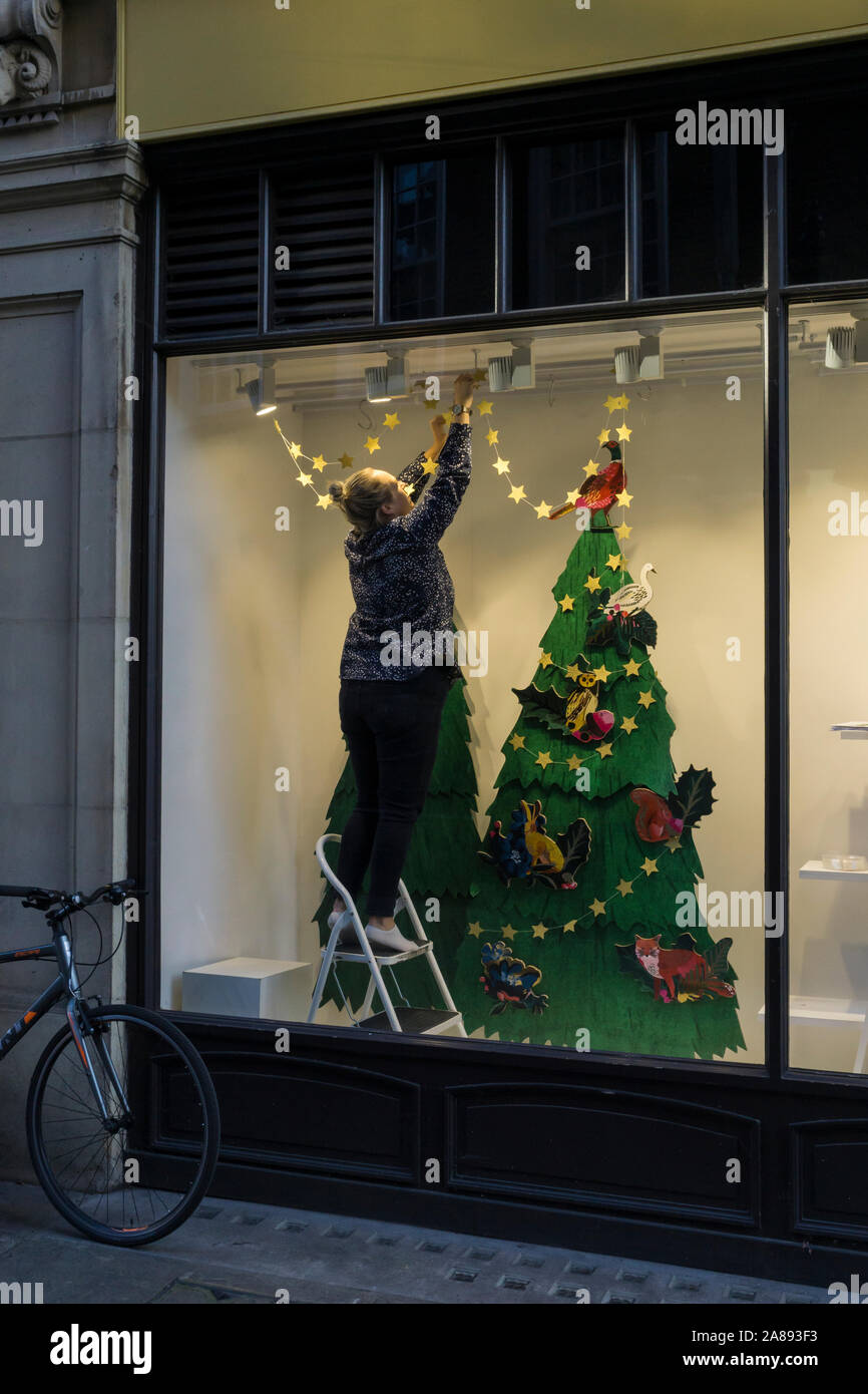 Finestra dresser preparazione vetrina di Natale per visualizzare Sussex Street Cambridge Città 2019 Foto Stock