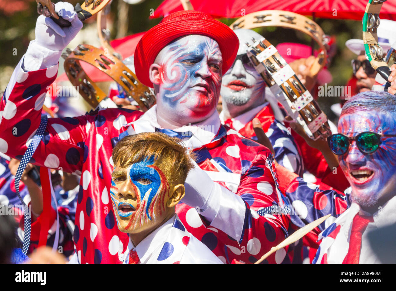 Il carnevale giullari in un colorito luminoso vivaci costumi o abiti fantasiosi eseguire durante il Nuovo Anno giorno tradizionale street parade di Cape Town Foto Stock