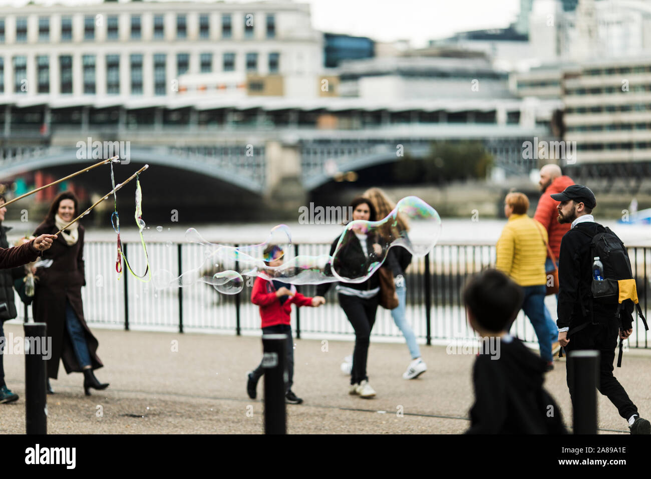 I bambini si divertono con bolle gigante vicino alla Tate Modern Foto Stock