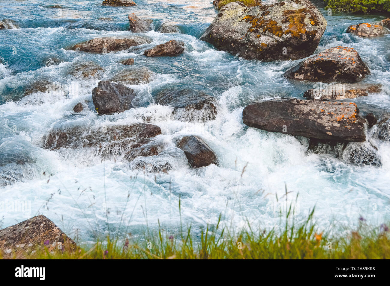 Ruvida flusso di fiume. Il blu dell'acqua di fiume di montagna, la marea sul mare con acque turchesi e banche di pietra Foto Stock